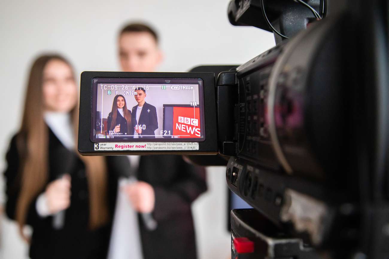 A girl and a boy filming content on television